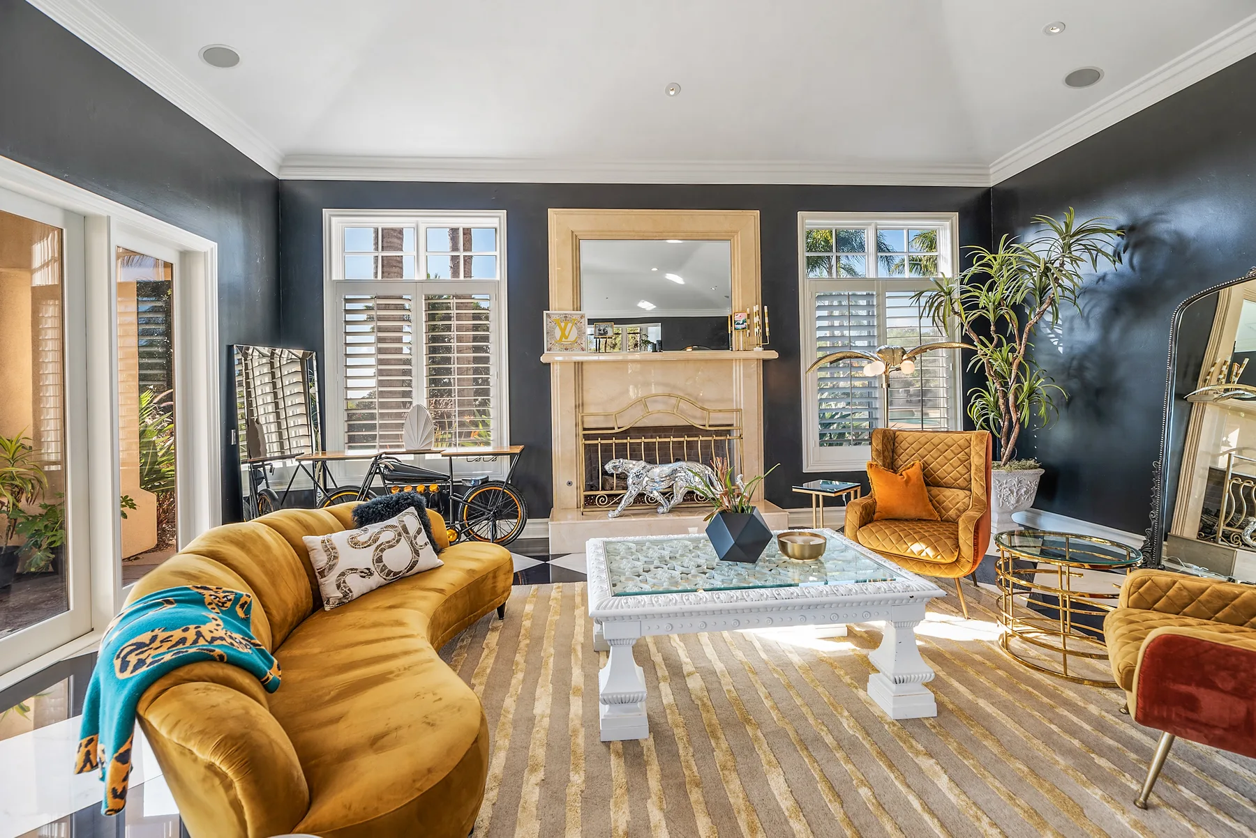 A living room with dark walls, a fireplace, and seating around a coffee table.