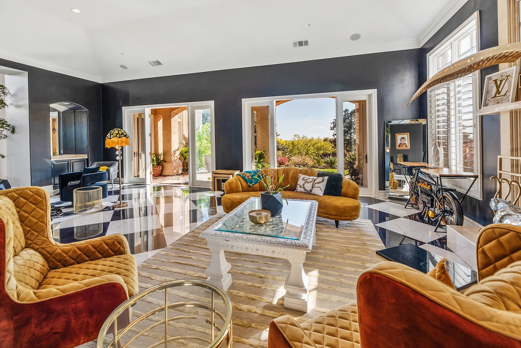A living room with seating around a coffee table and wide windows.