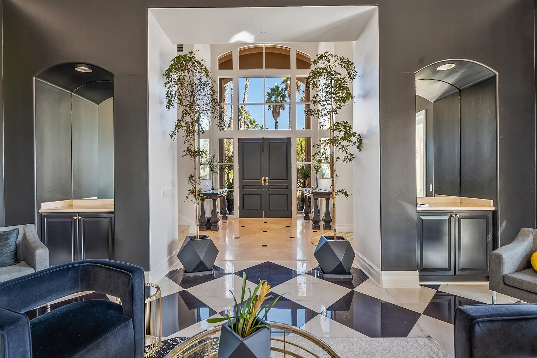 A grand entry hall features a dark double door and tall windows.
