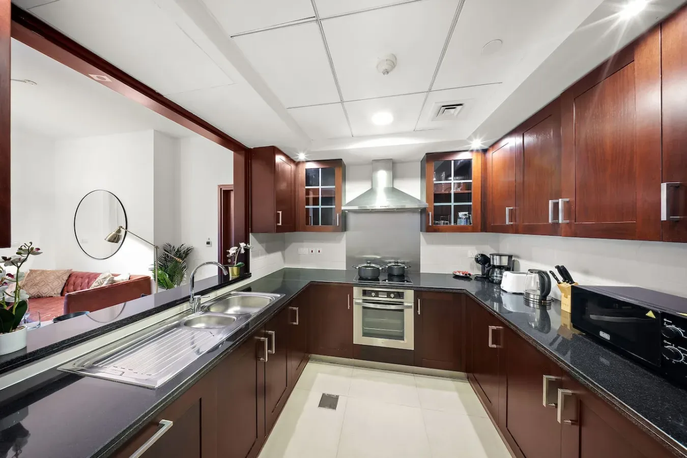 Una cocina moderna con gabinetes de madera oscura, electrodomésticos de acero inoxidable y encimeras oscuras.