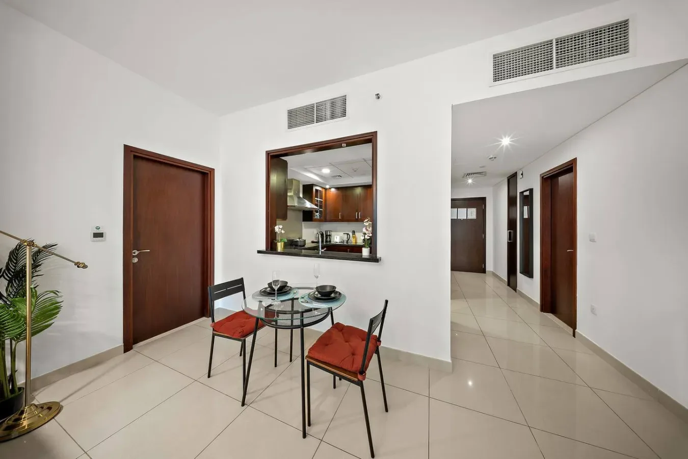 Una luminosa zona de comedor con mesa redonda y sillas junto a una abertura hacia la cocina.