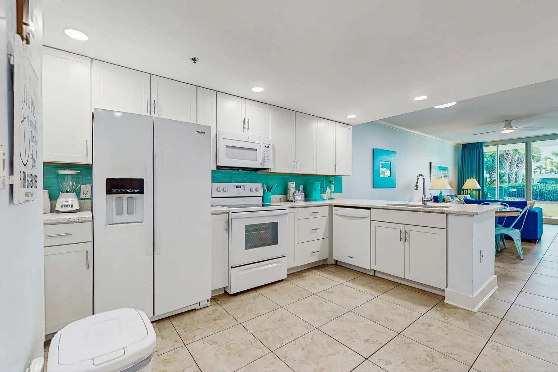 A bright kitchen with white cabinets and a refrigerator.