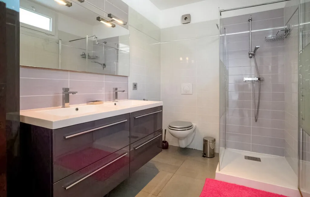 Un baño con lavabo doble y ducha.