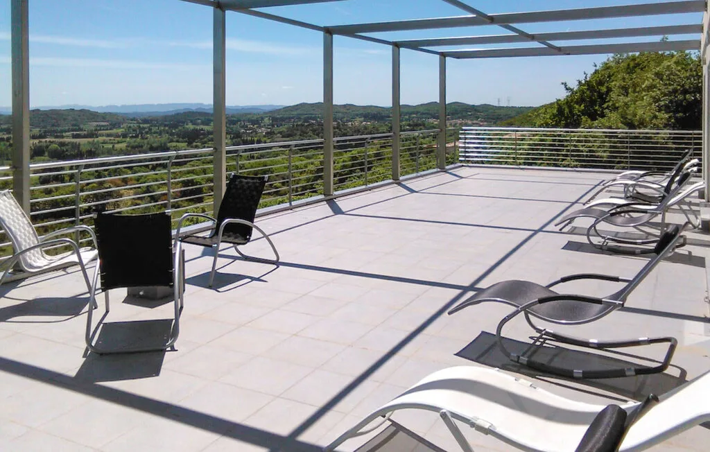 Una amplia terraza al aire libre con asientos de descanso y vistas a colinas verdes.