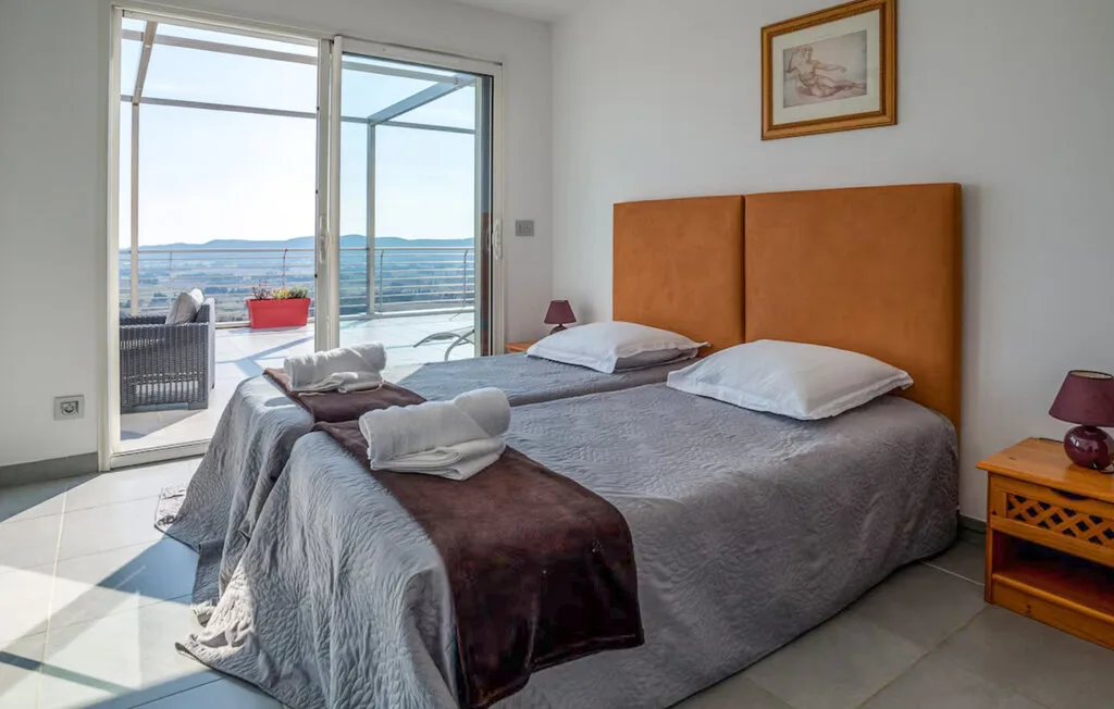 Un dormitorio con una cama doble y puertas corredizas de vidrio que dan a un balcón.