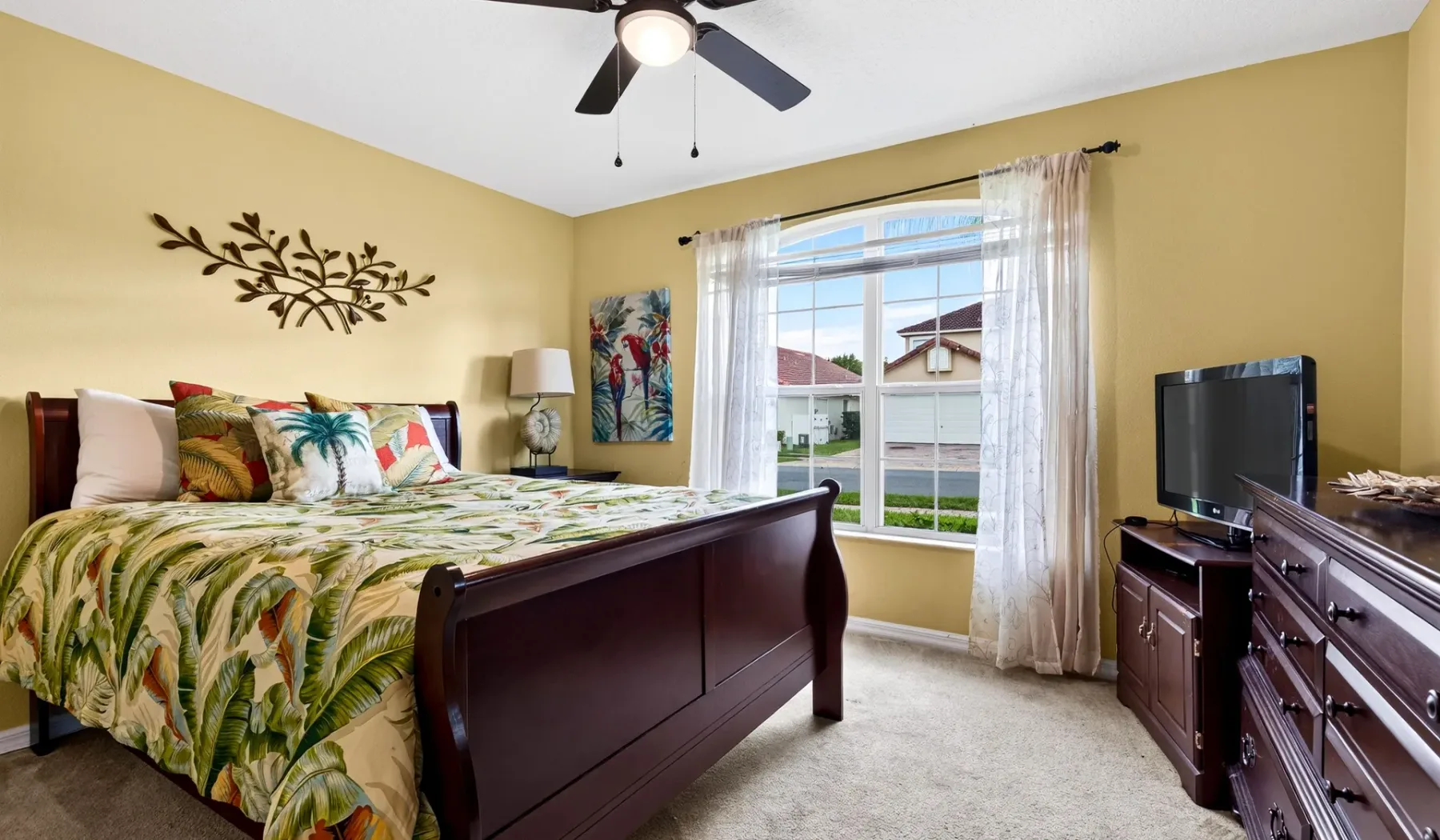 Un dormitorio con una cama, una ventana y muebles de madera oscura.