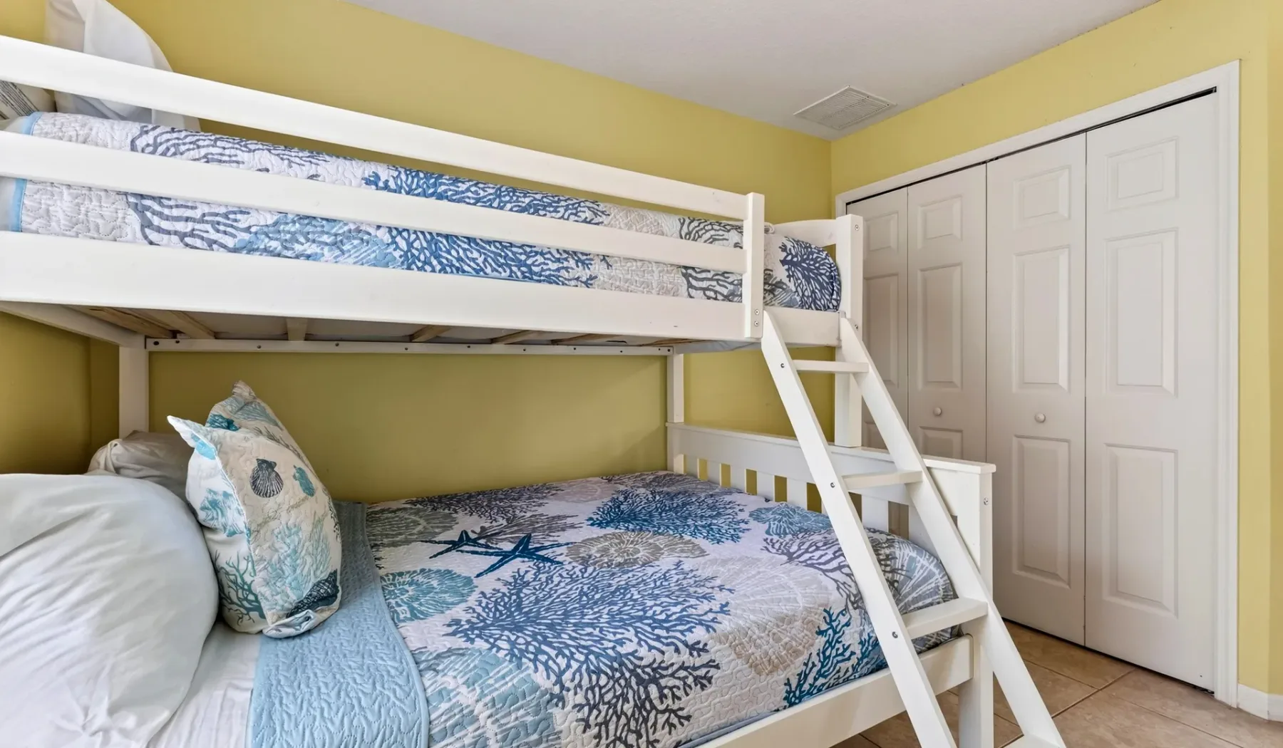 Un dormitorio con una litera vestida con ropa de cama azul y blanca.