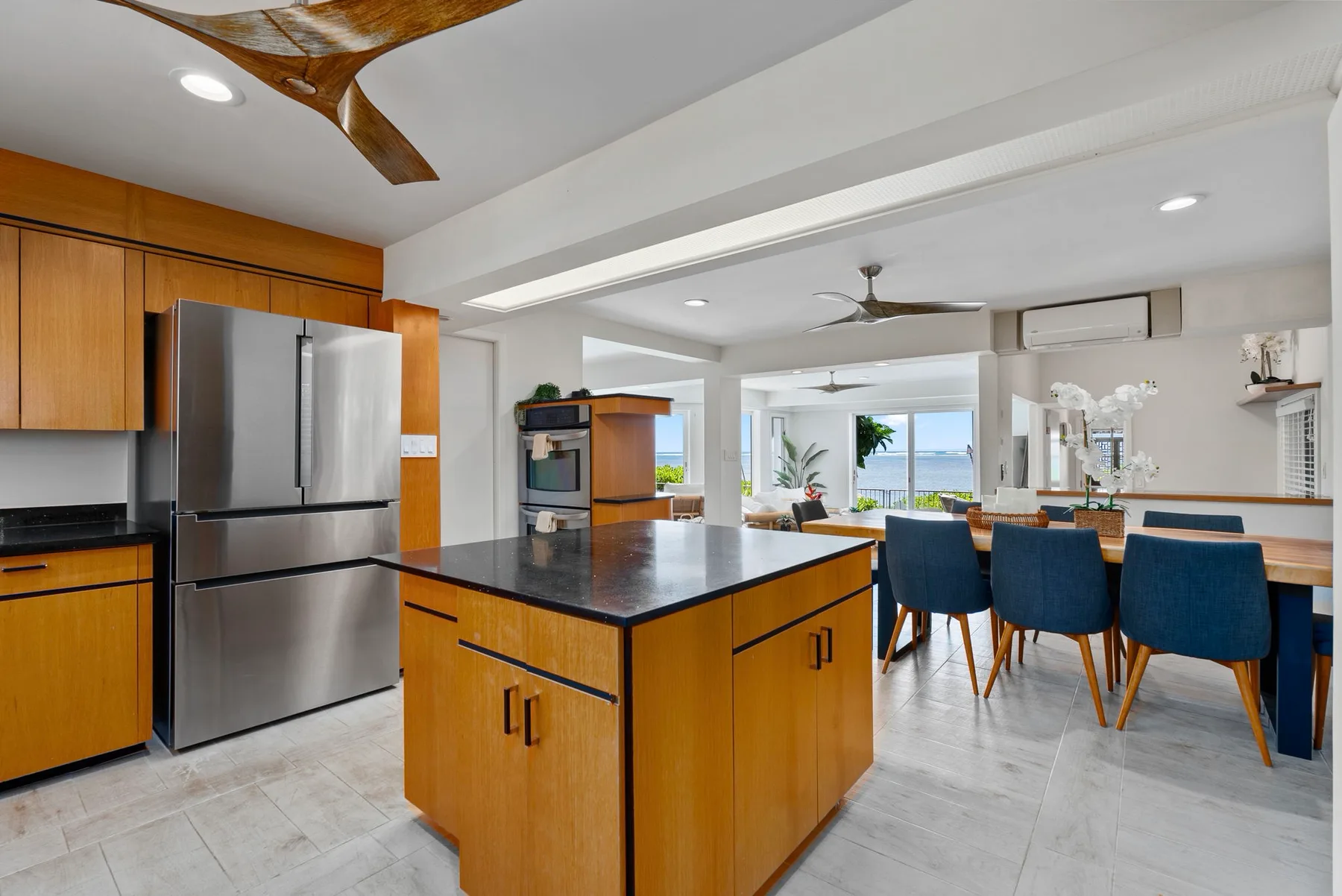 A bright kitchen with a central island and windows overlooking the water.