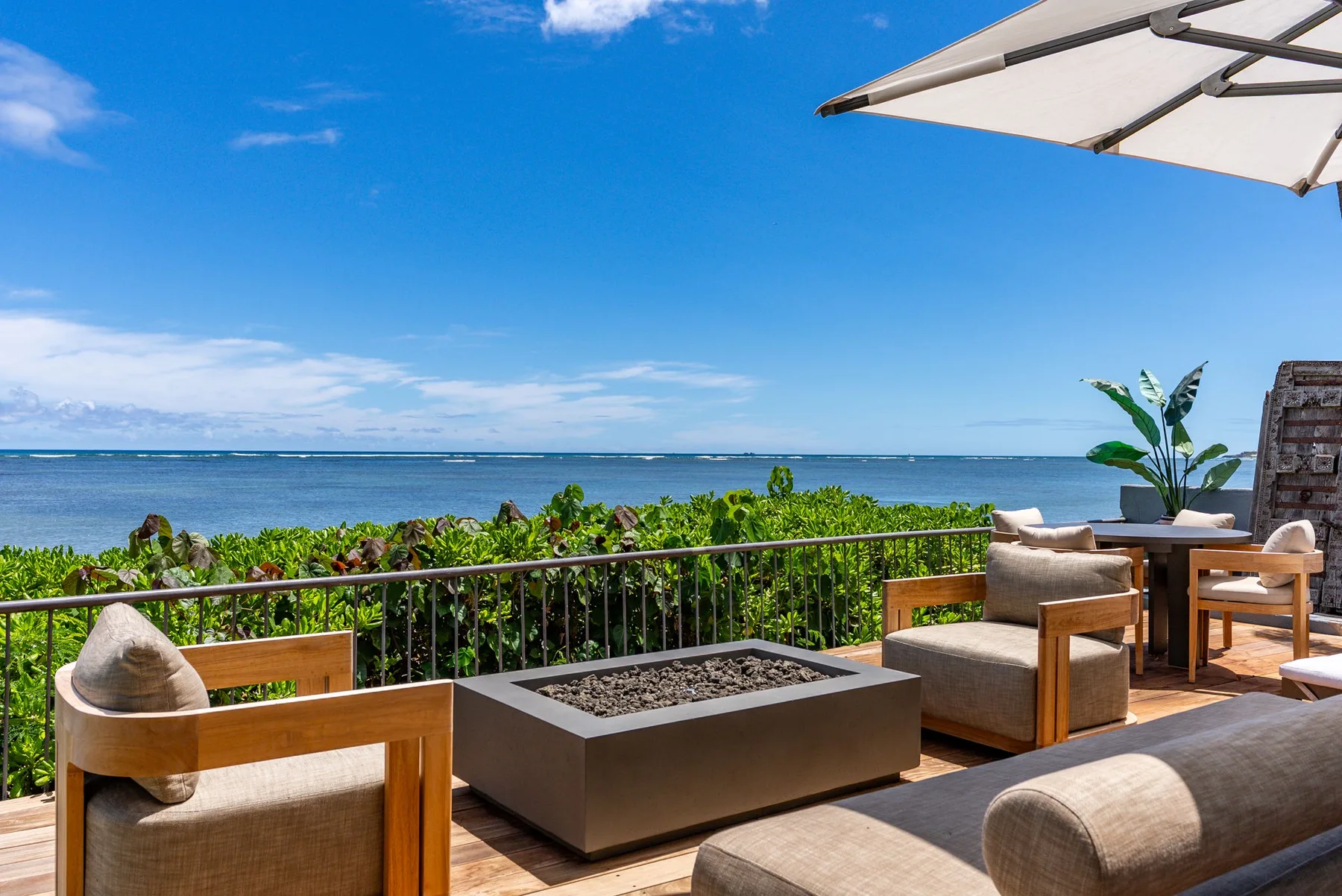 An outdoor terrace with seating and a view of the ocean.