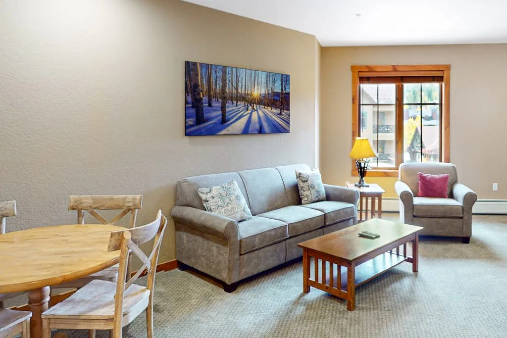 A living room with a sofa, armchair, and wooden coffee table.