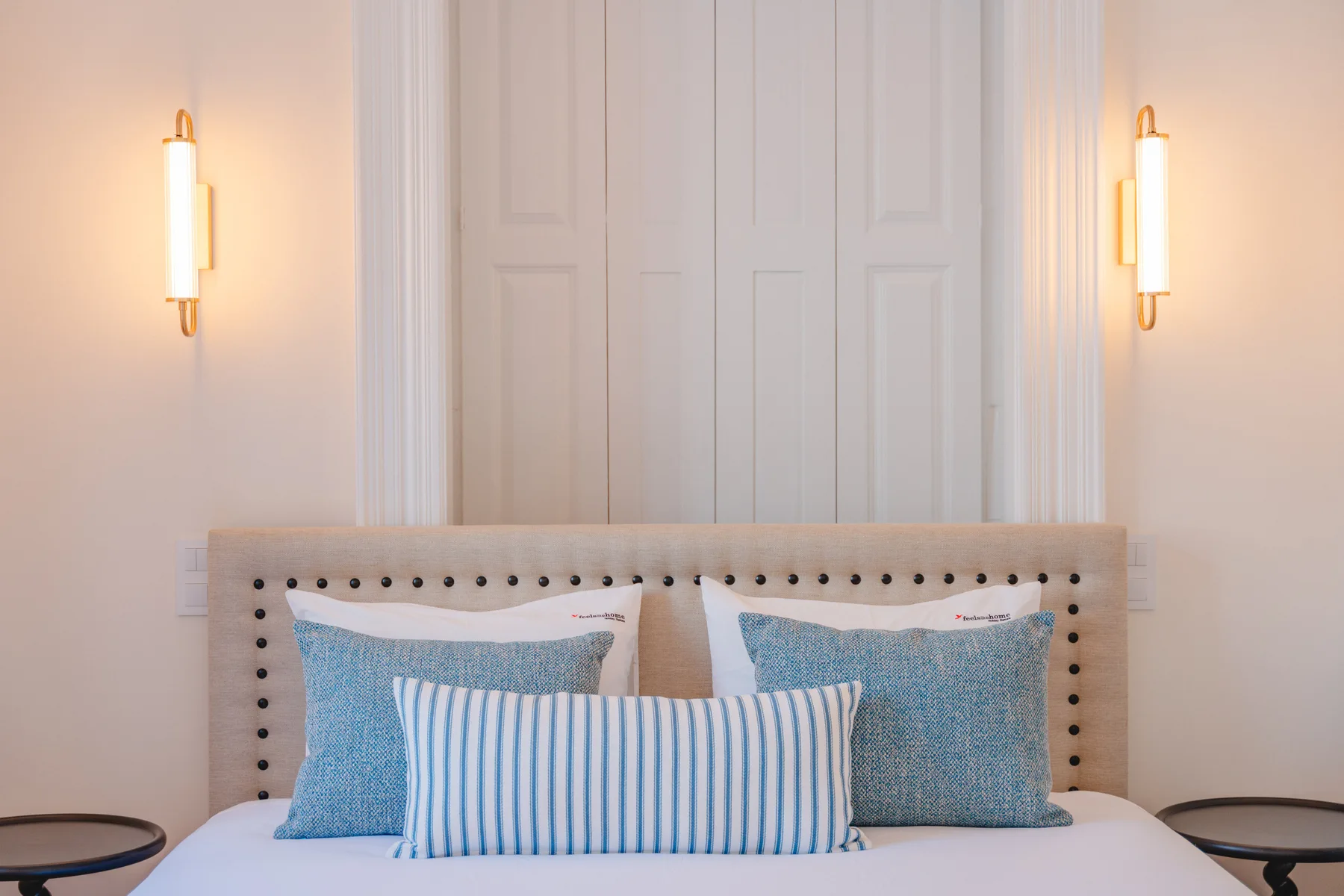 Un dormitorio con una cama vestida con ropa de cama azul y blanca.