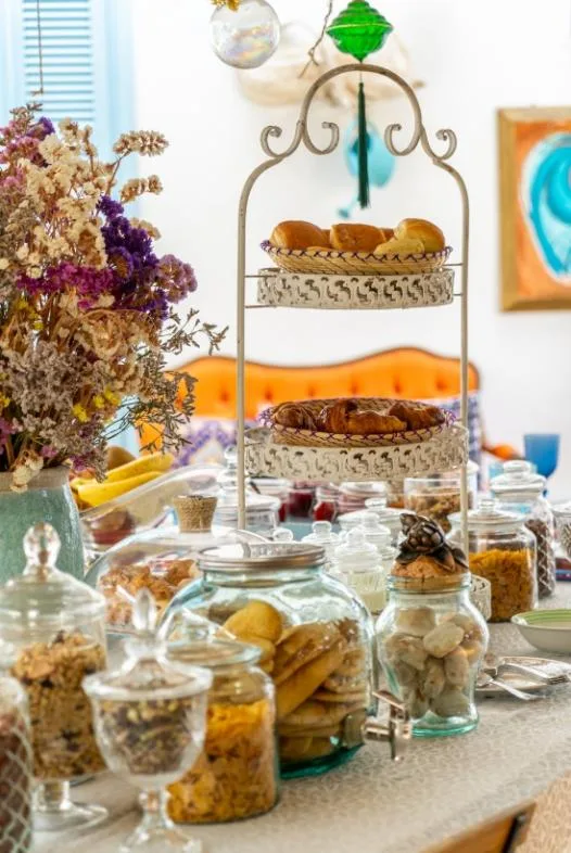 Bollería, cruasanes y galletas para el desayuno sobre una mesa decorada con flores.