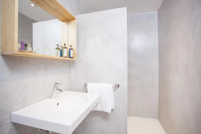A bright bathroom with a white sink and a towel hanging nearby.