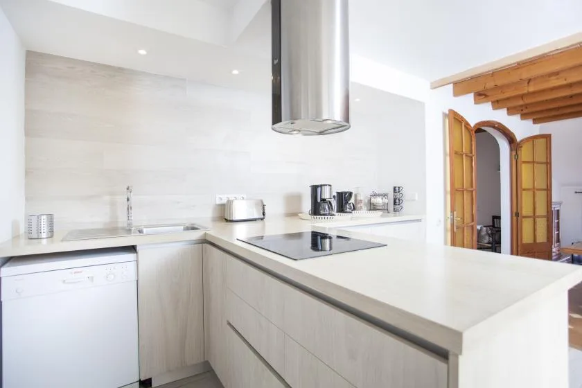 A modern kitchen with a broad island and stainless steel range hood.