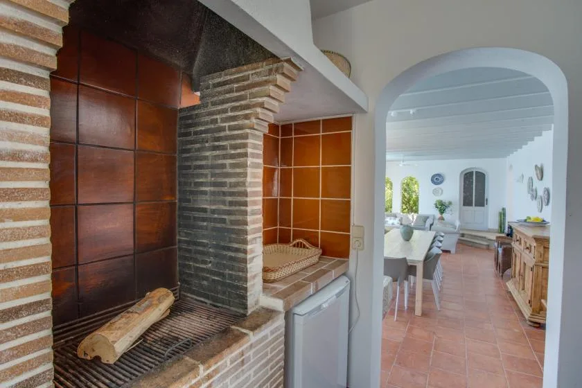 A brick fireplace beside an arched opening into a dining area.