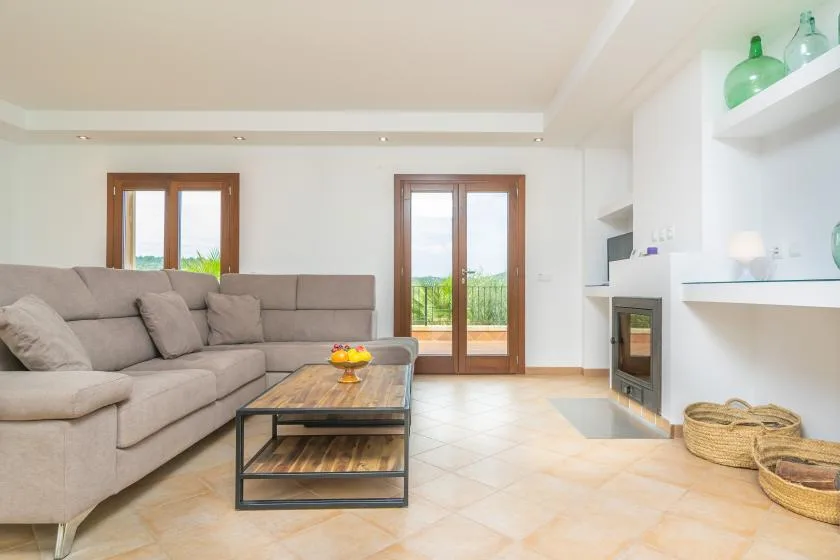 Una sala luminosa con una zona de estar y puertas de vidrio que dan a un balcón.