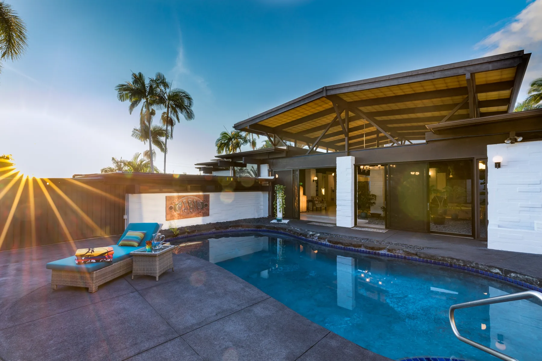 Una casa moderna da a una piscina y una zona de estar al aire libre.