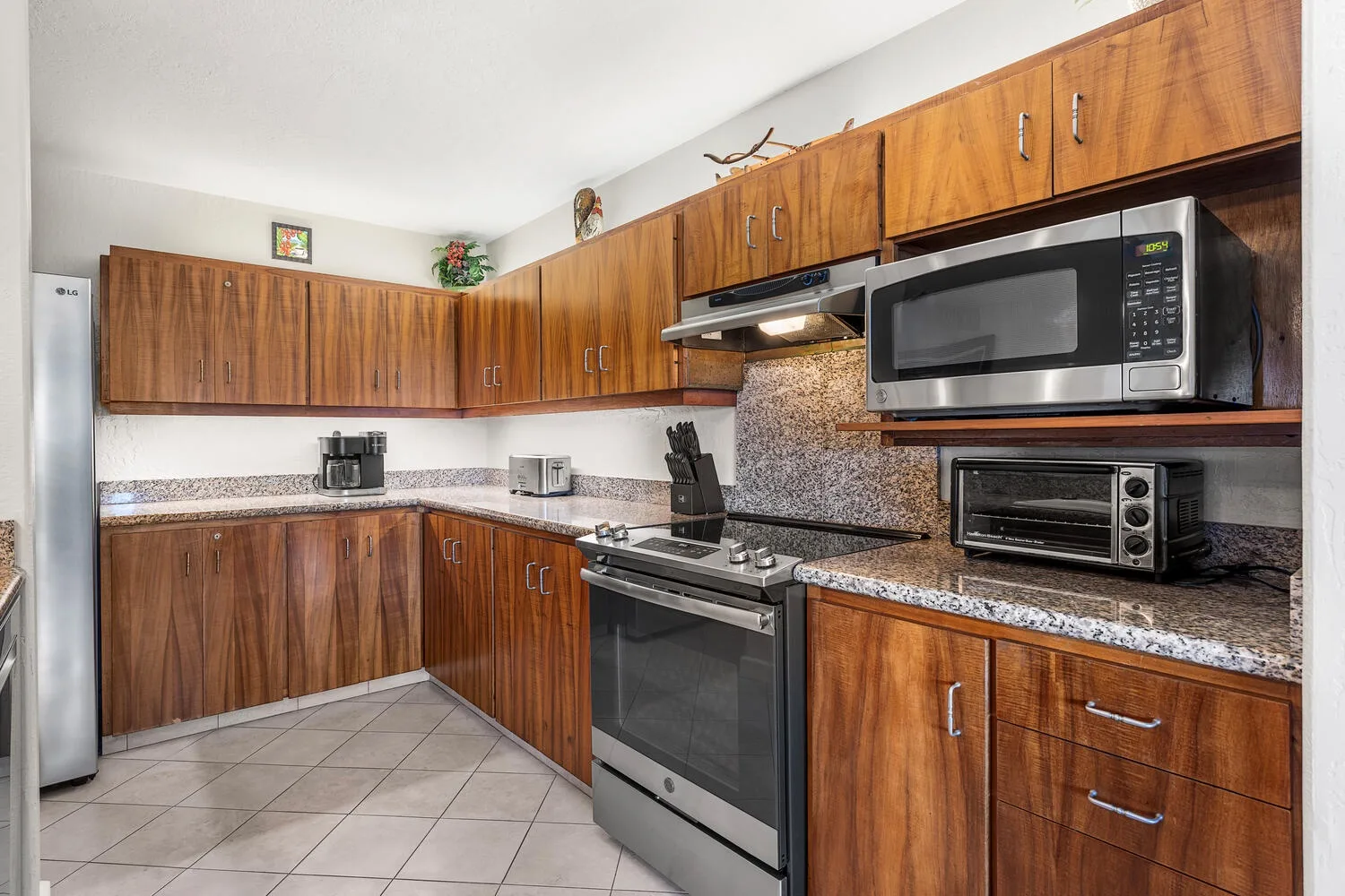 A kitchen with wood cabinets, a stove, and countertop appliances.
