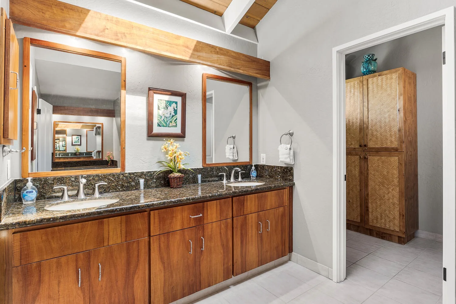 A bathroom vanity with a long counter and mirrors.