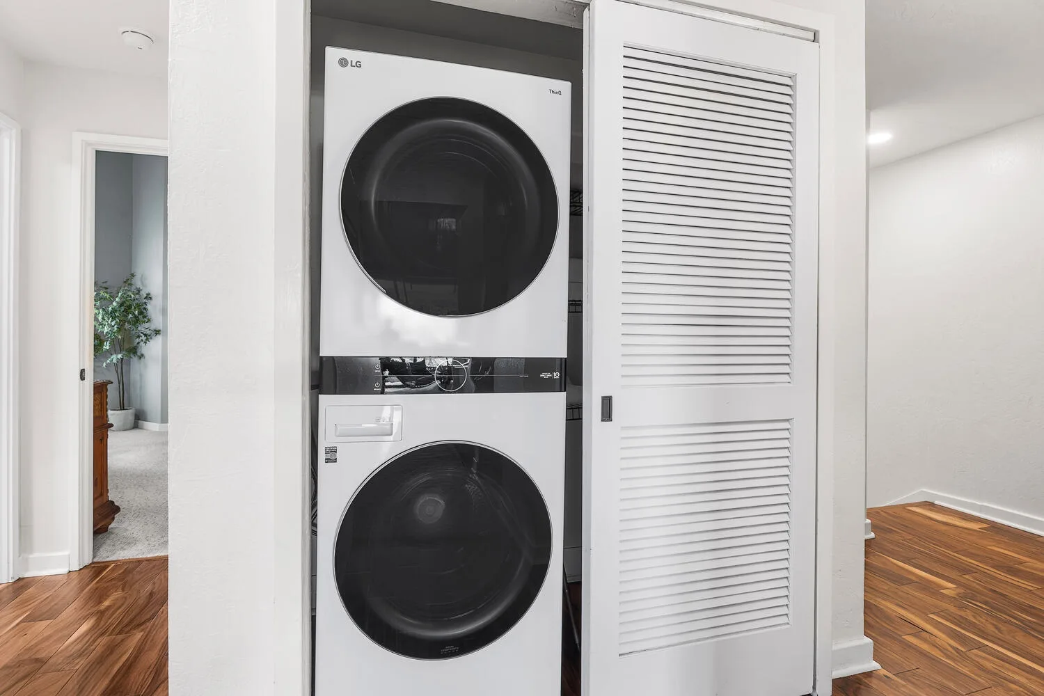 A stacked washer and dryer are set into a white laundry closet.