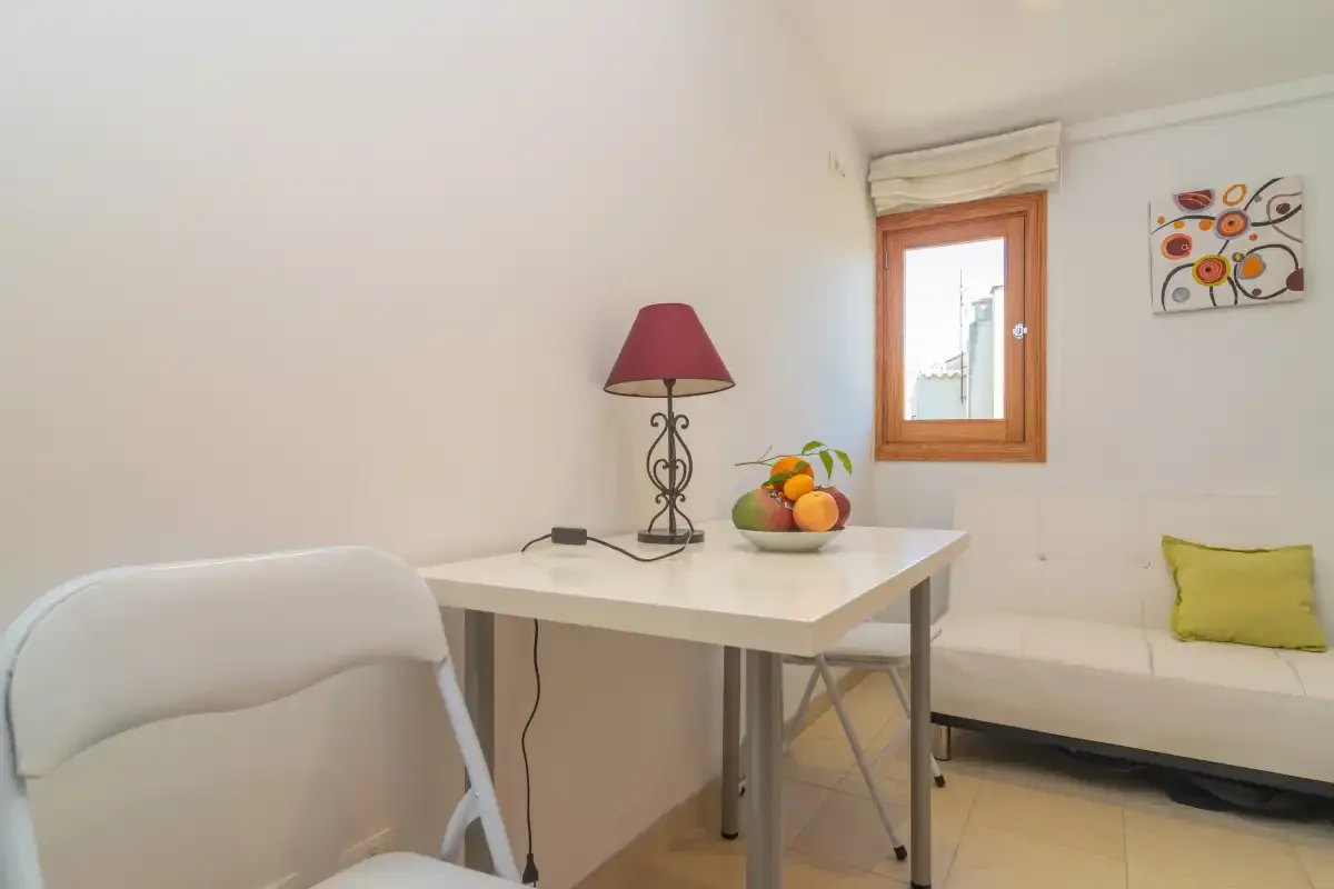 A bright room with a table, a chair, and a window.