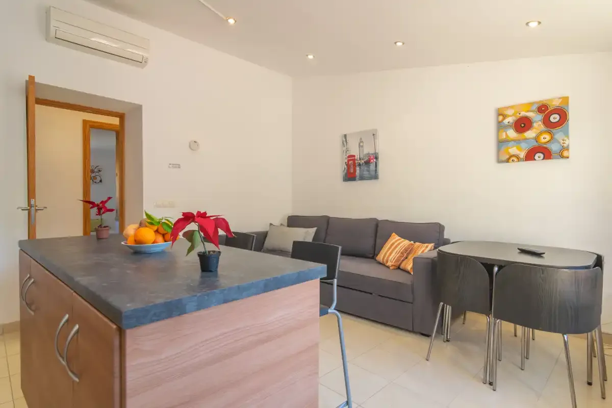 A dining and living area with a kitchen island, seating, and colorful wall art.