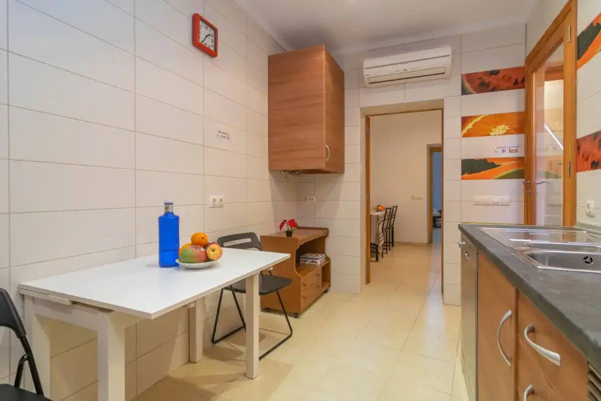 A tiled kitchen with a dining table and countertop.