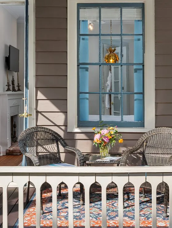 Porch with wicker patio furniture and flowers