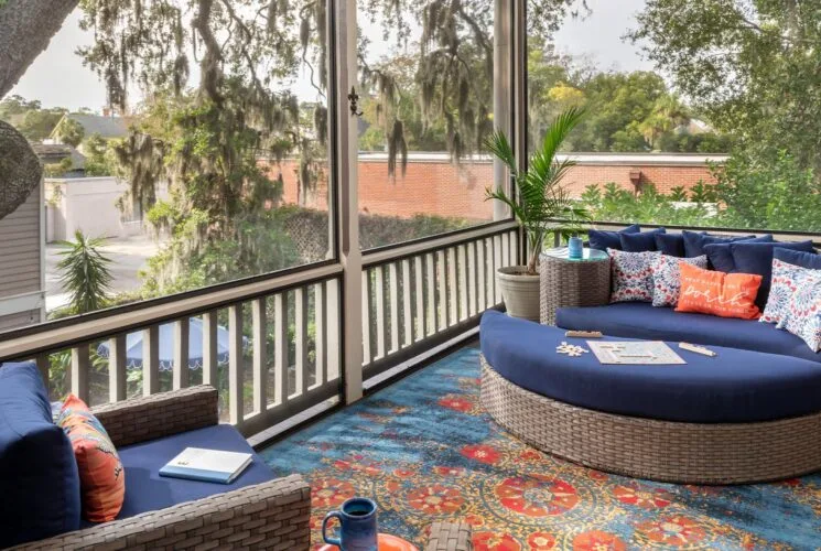 Screened porch with wicker patio furniture and area rug