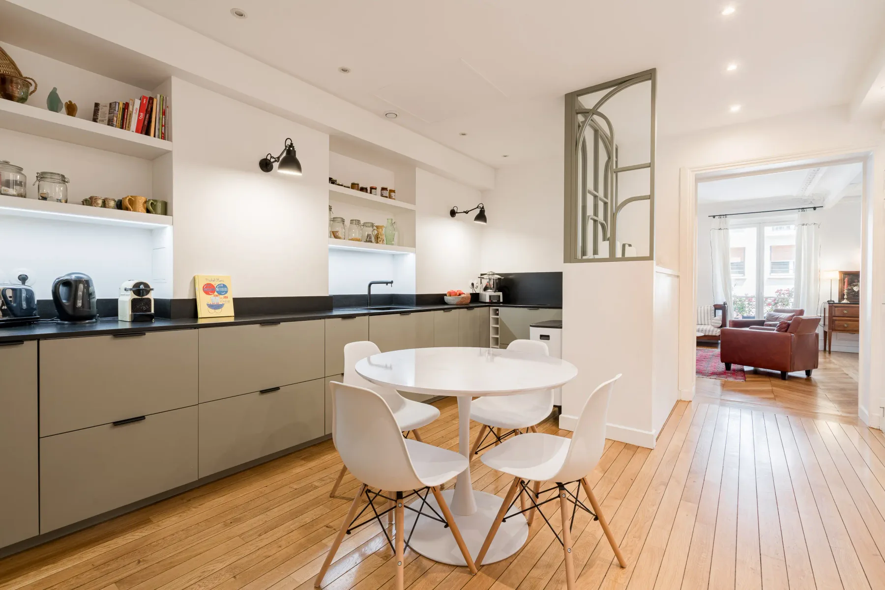 A bright kitchen and dining area with a round table and open shelves.