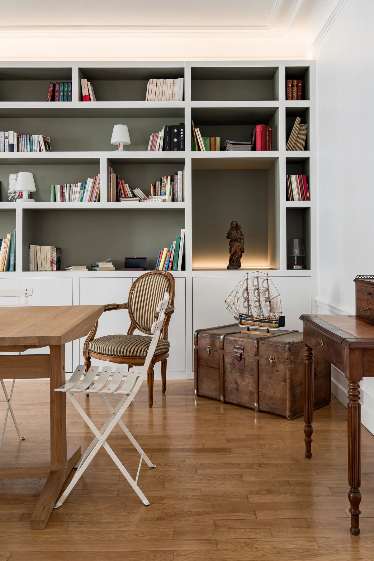 A study with built-in bookshelves, a wooden desk, and a chair.