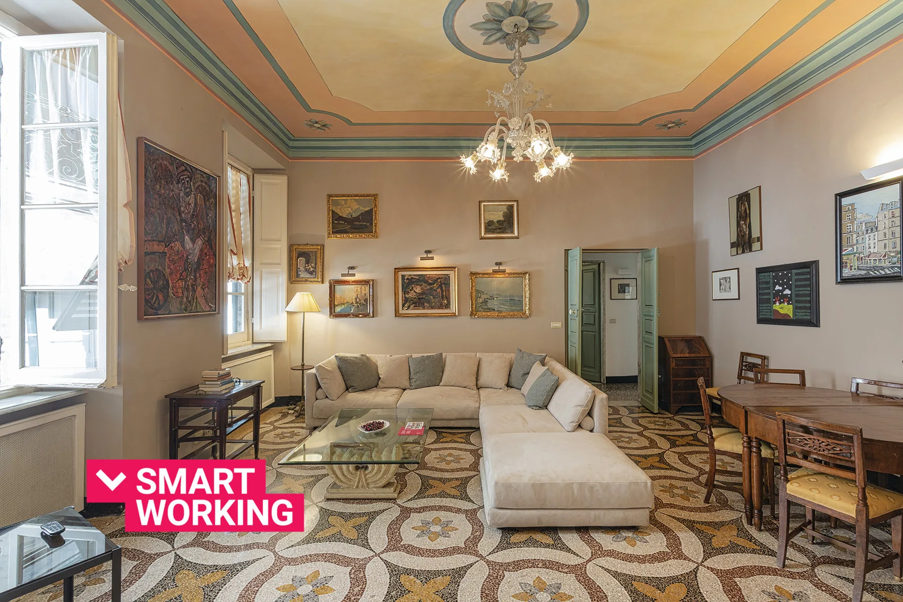 Una sala de estar con asientos, cuadros y un suelo con motivos ornamentales.