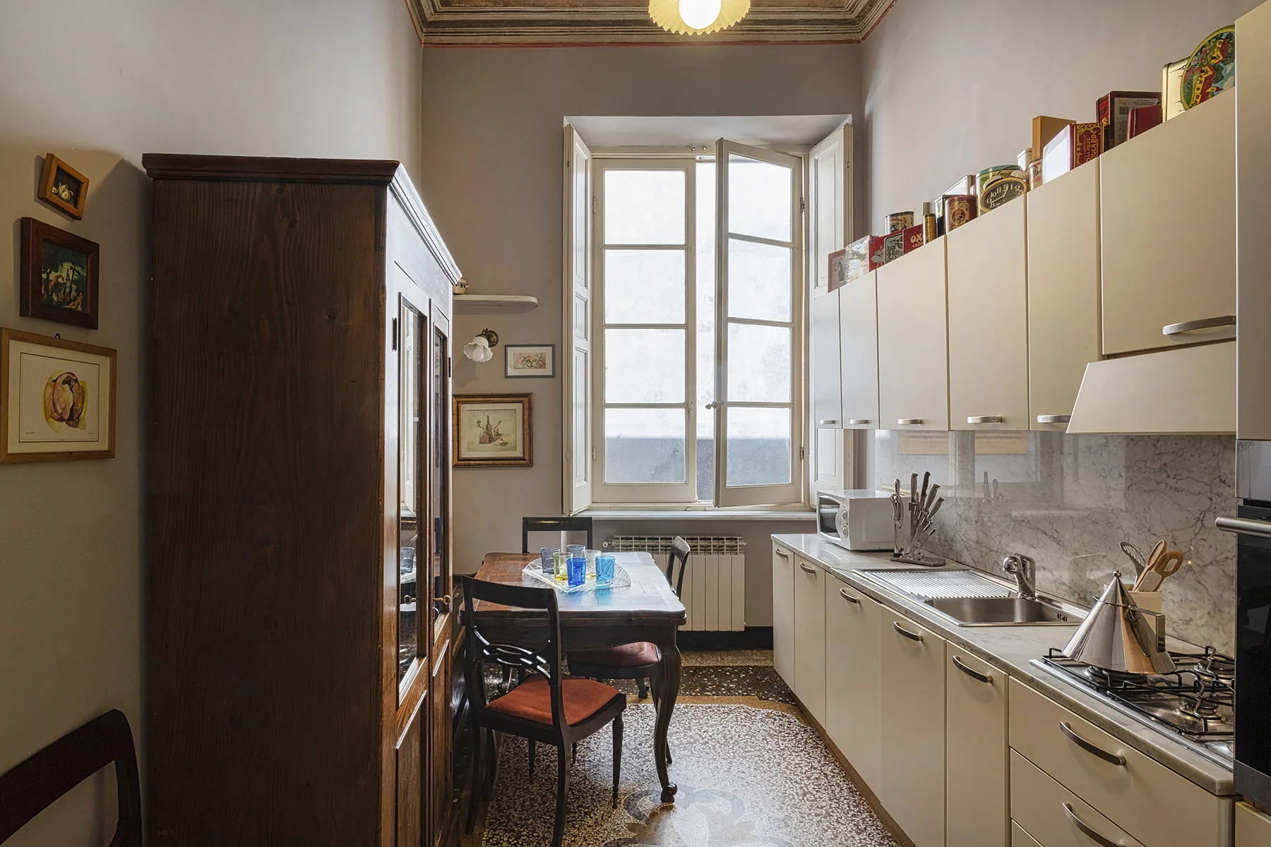 Una cocina con una mesa de comedor junto a una ventana grande.