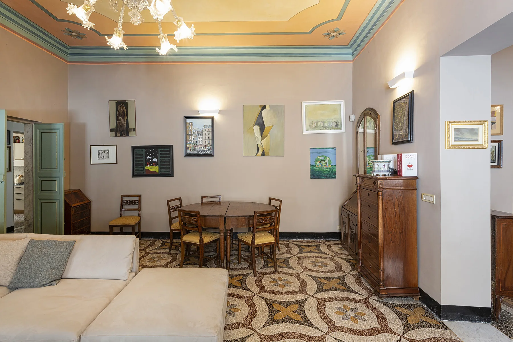 Una habitación amueblada con cama, mesa de comedor y cuadros en las paredes.