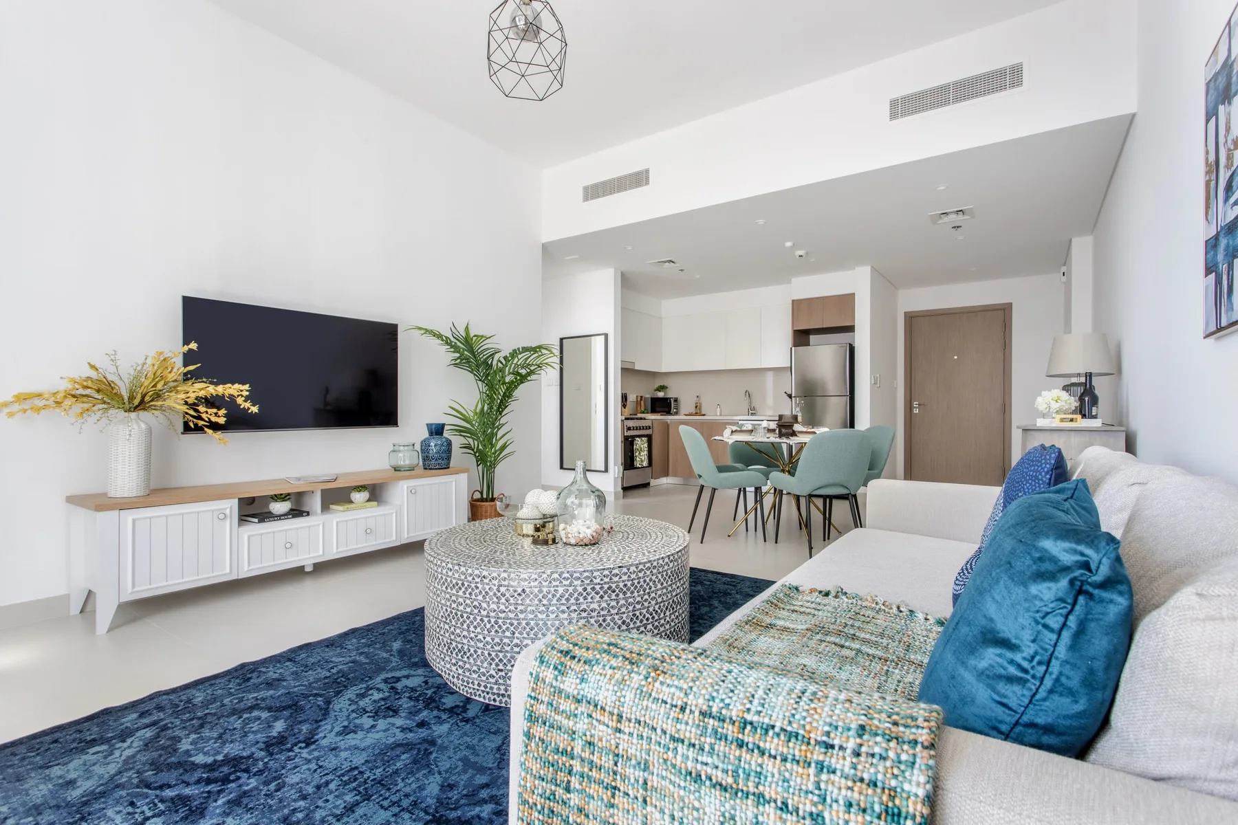 A bright living room opens onto a dining area and kitchen.