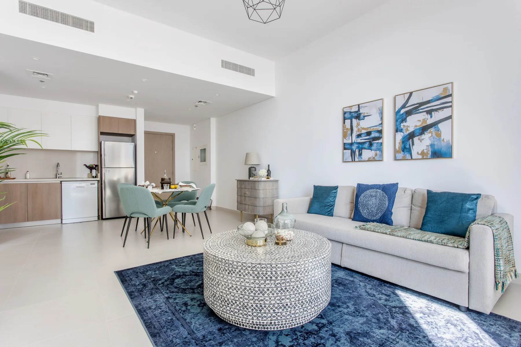 A bright living room with a sofa, patterned rug, and round coffee table.