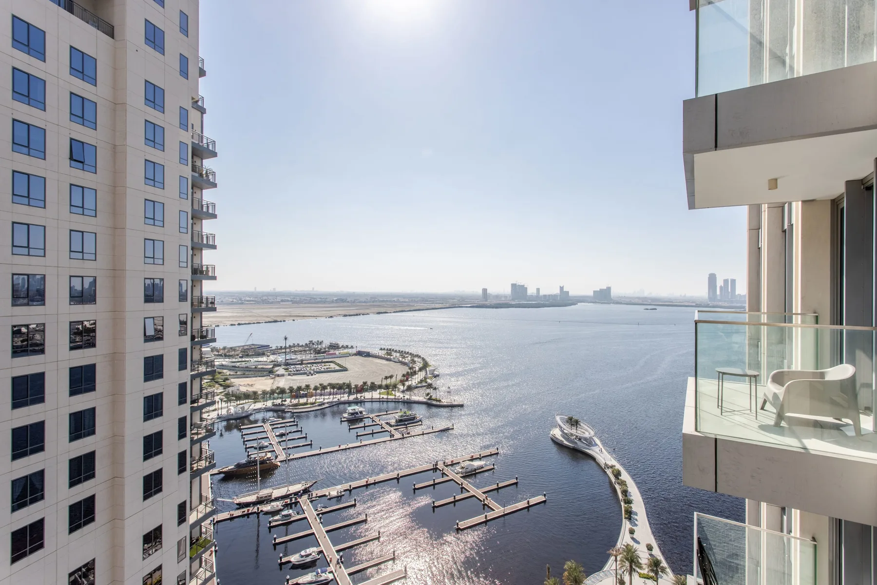 A waterfront marina and open water viewed between modern high-rise buildings.