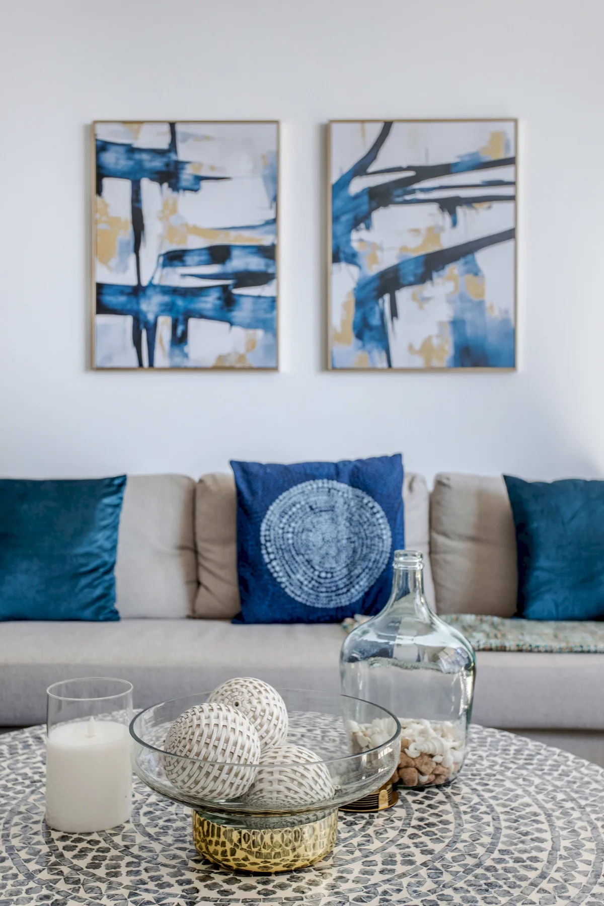 A living room seating area with abstract artwork above the sofa.