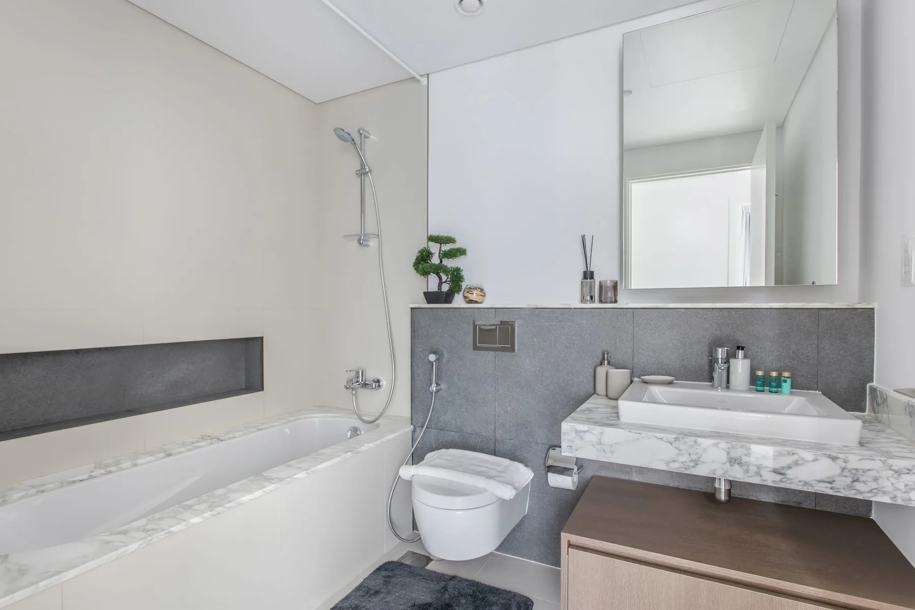 A bright bathroom with a bathtub, toilet, and vanity.