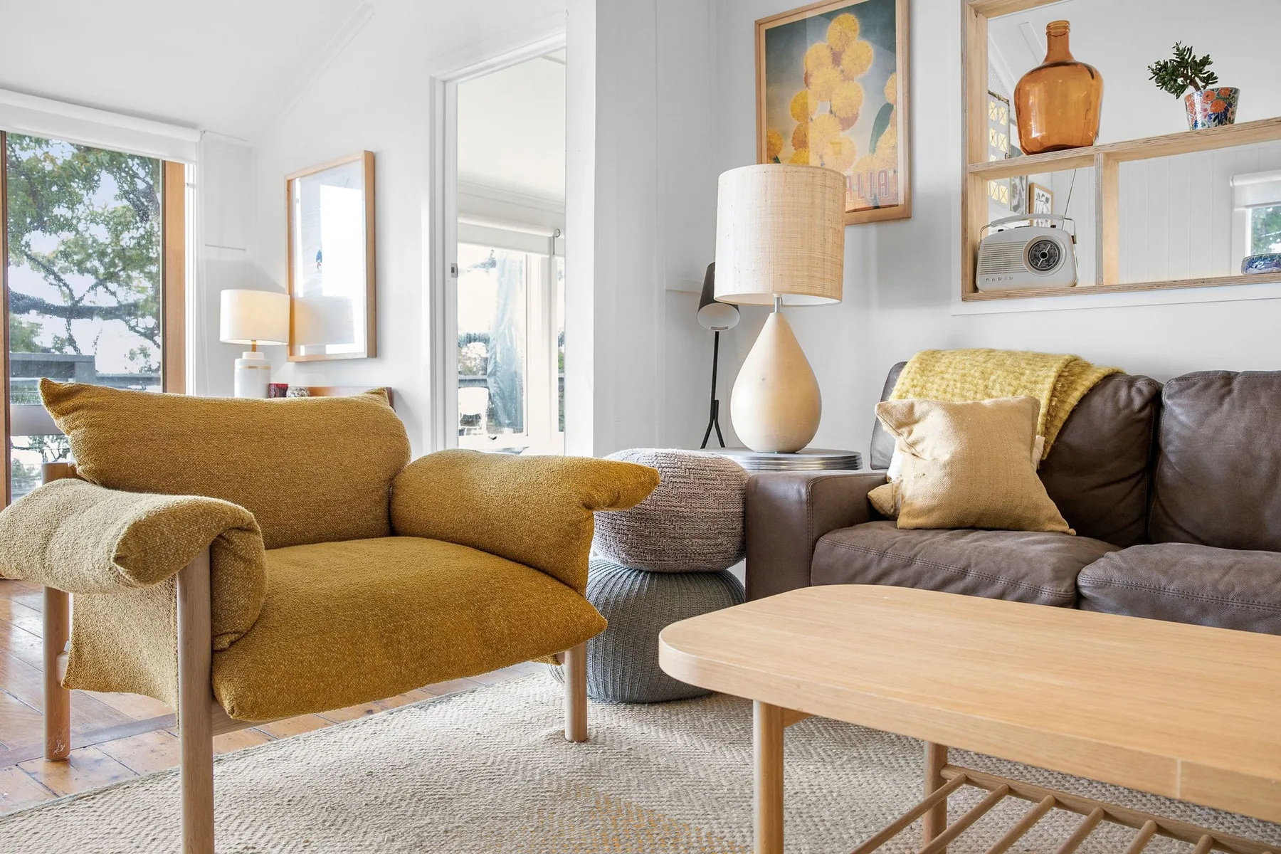A bright living room with seating around a light wood coffee table.