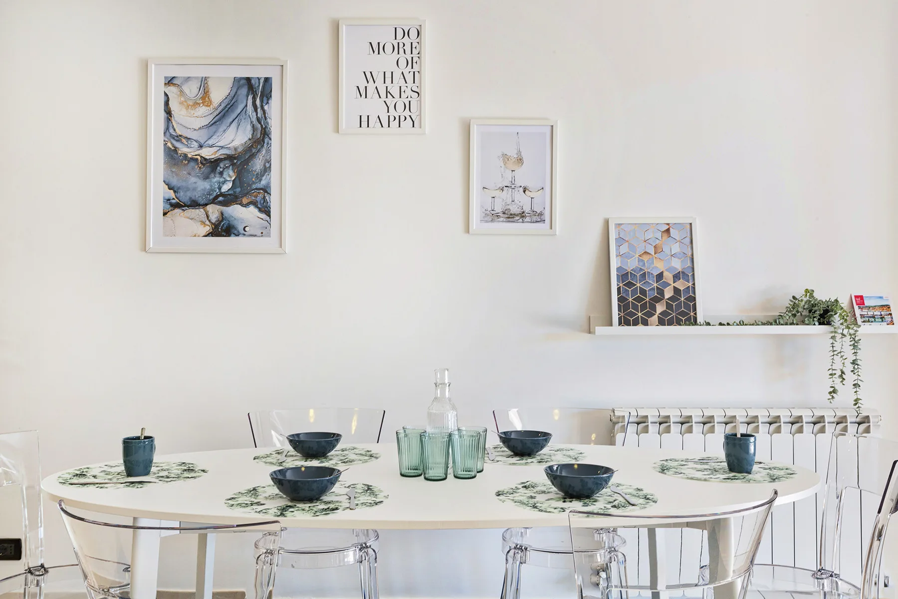 A bright dining area with a set table and framed artwork on the wall.