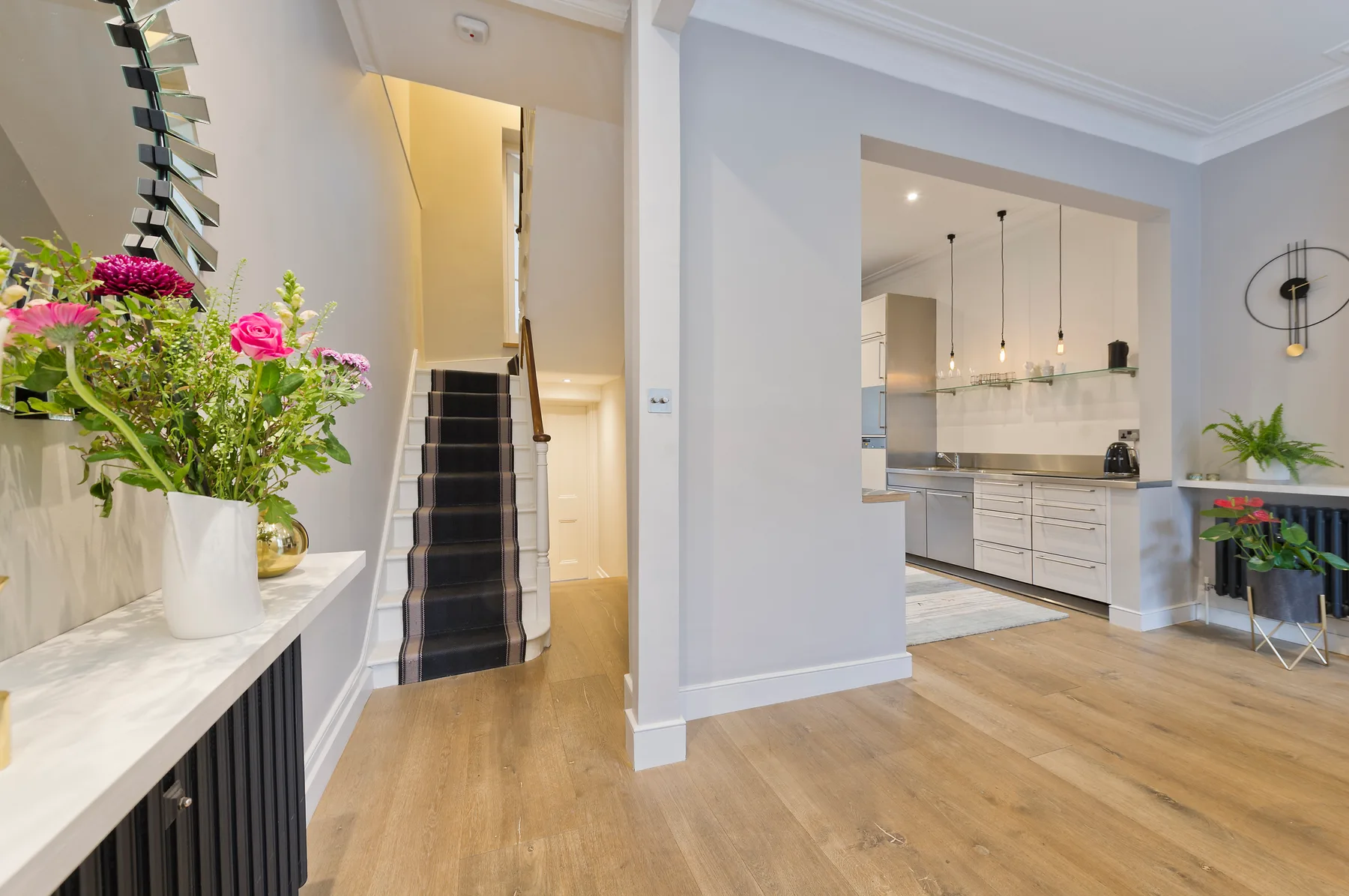 A bright entryway opens to a kitchen, with a staircase beside the hall.