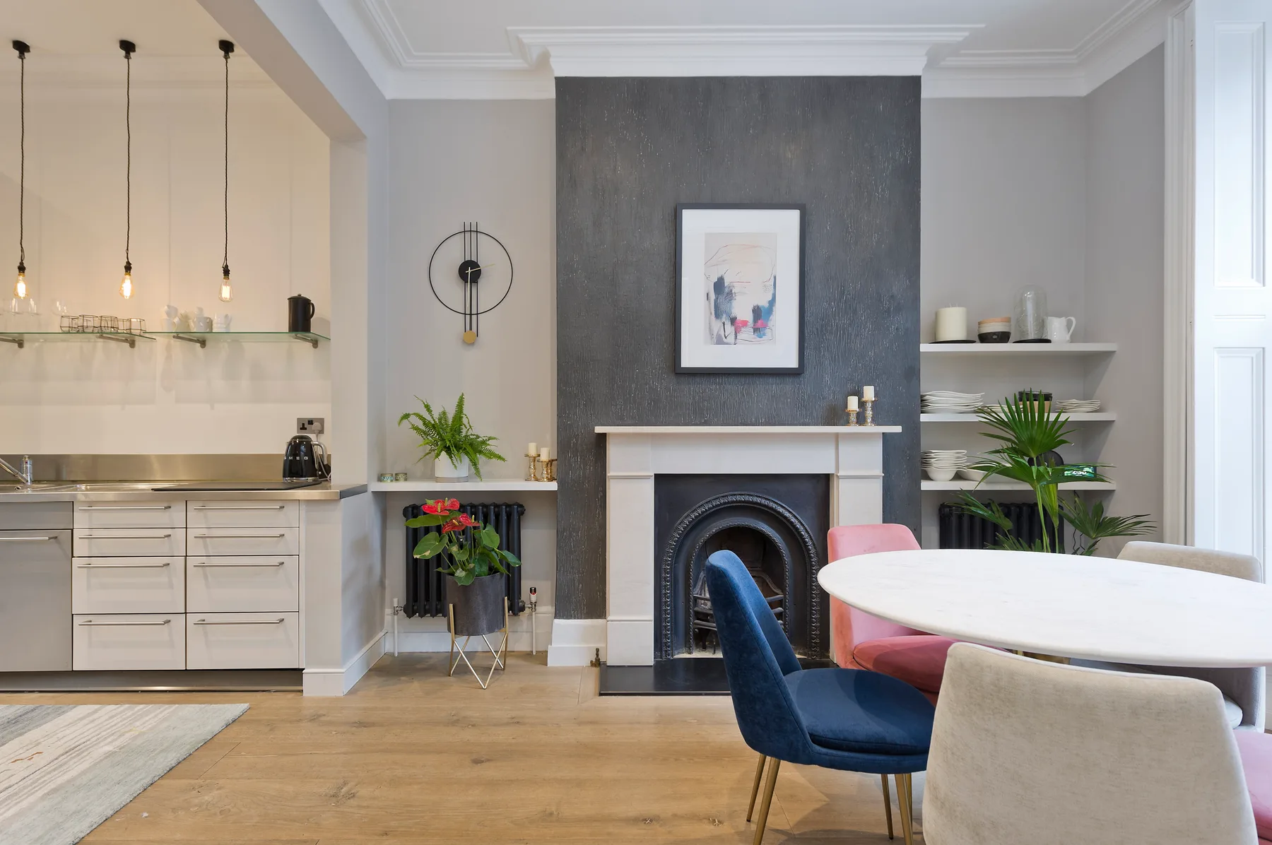 A bright living and dining area with a fireplace, table, and seating.