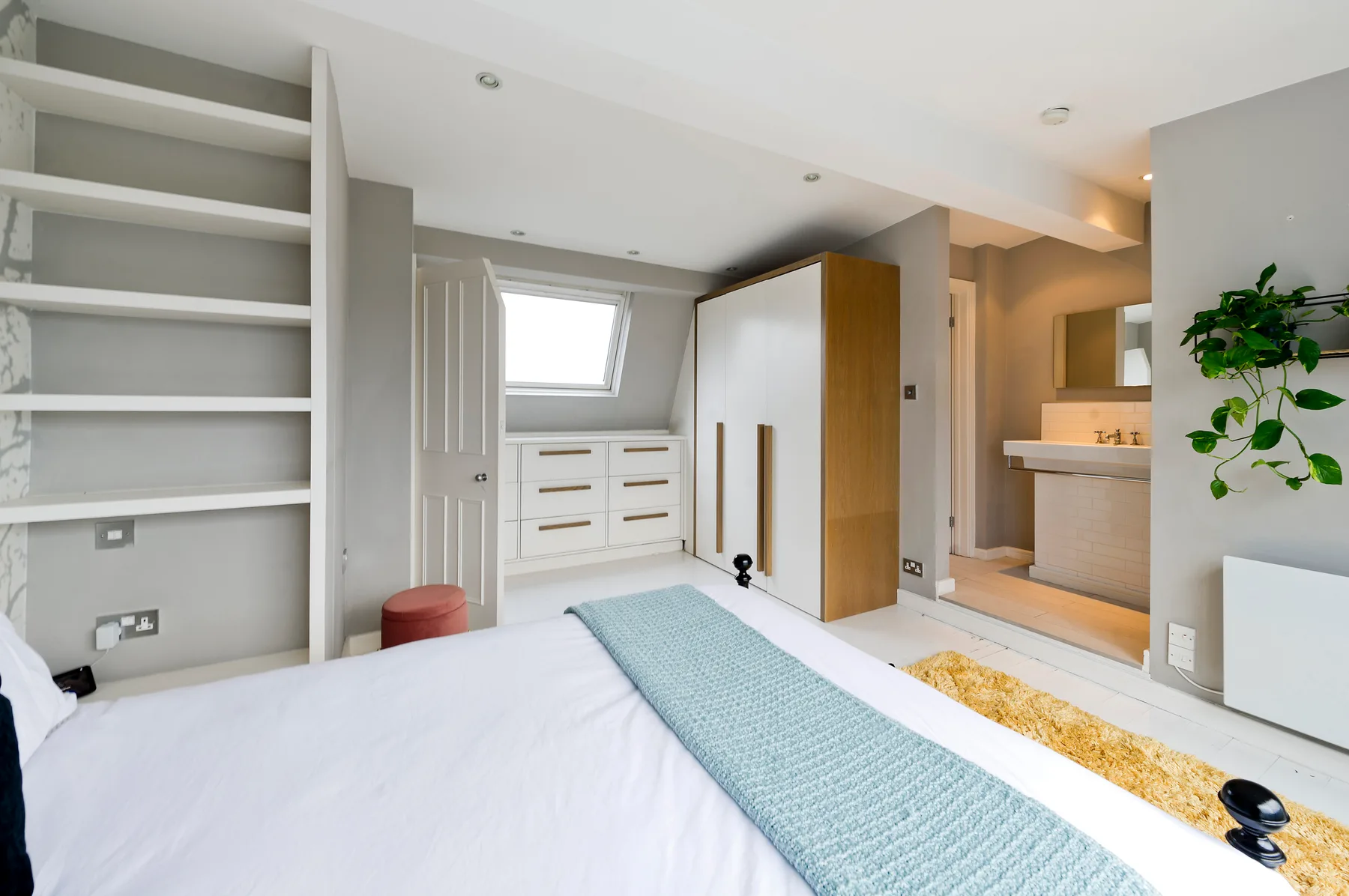 Bedroom with a bed, built-in storage, and an adjoining bathroom.