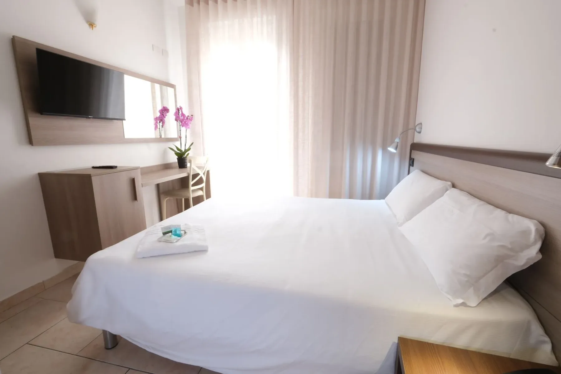 Hotel room with a bed and television.
