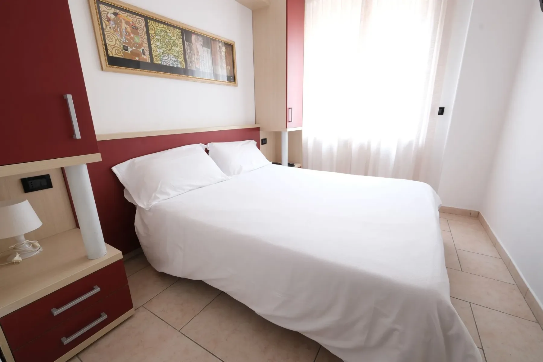 Dormitorio del hotel con una cama grande y una mesa de noche.
