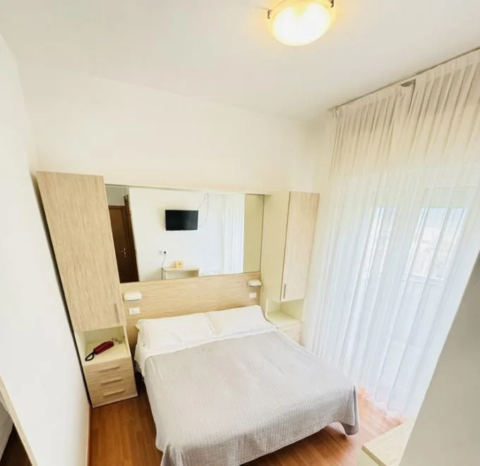 Camera accogliente con letto matrimoniale, toni caldi e luce soffusa.