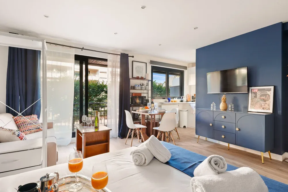 Una sala luminosa con comedor y una pared decorativa azul.