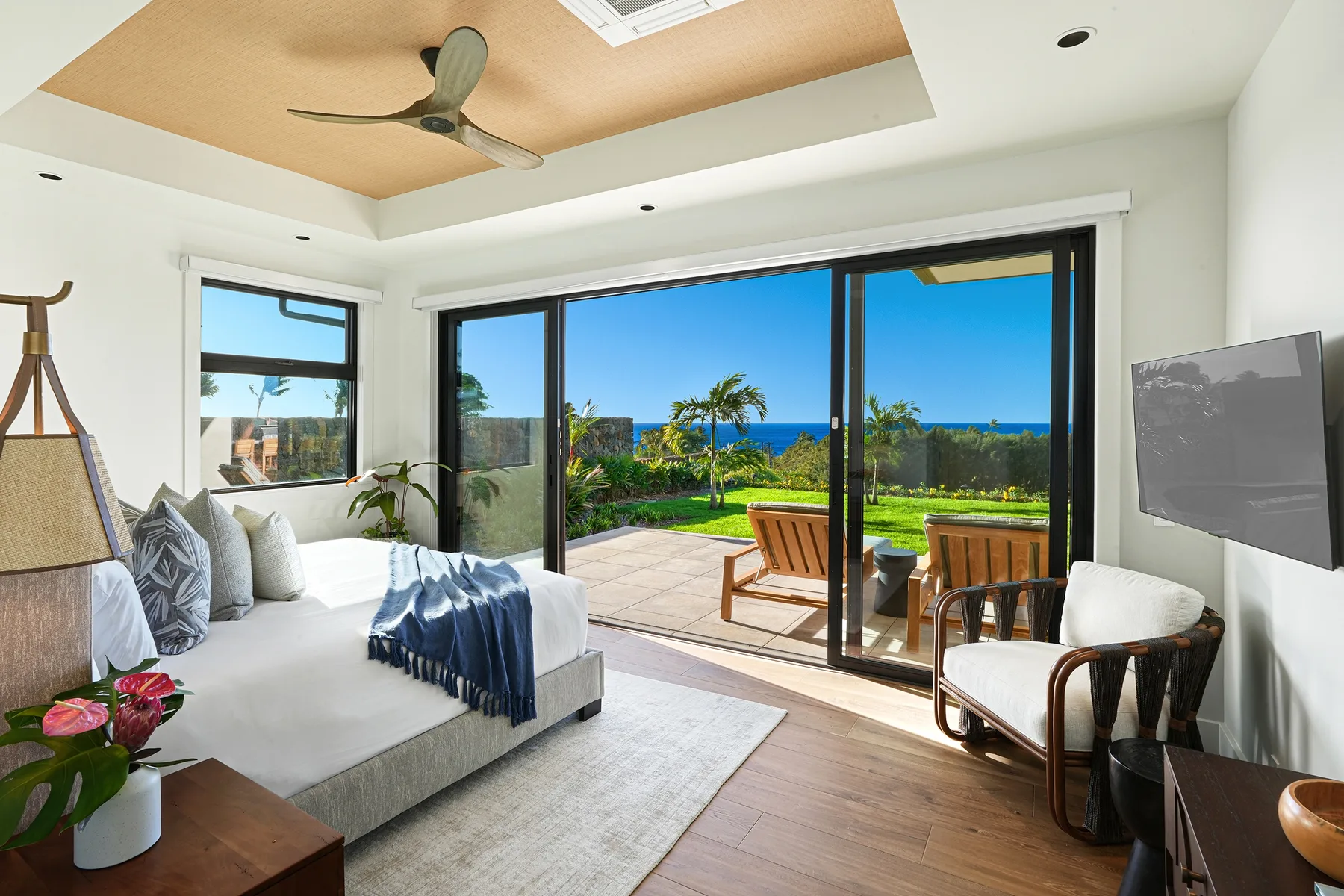 A bright living room opens onto a patio through large glass doors.
