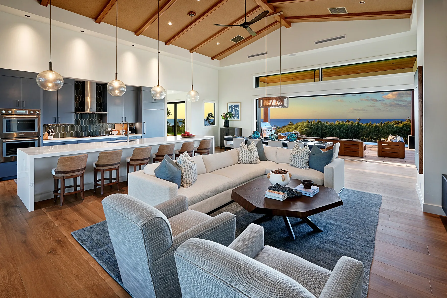 Open-plan living room and kitchen with seating facing a wide window.